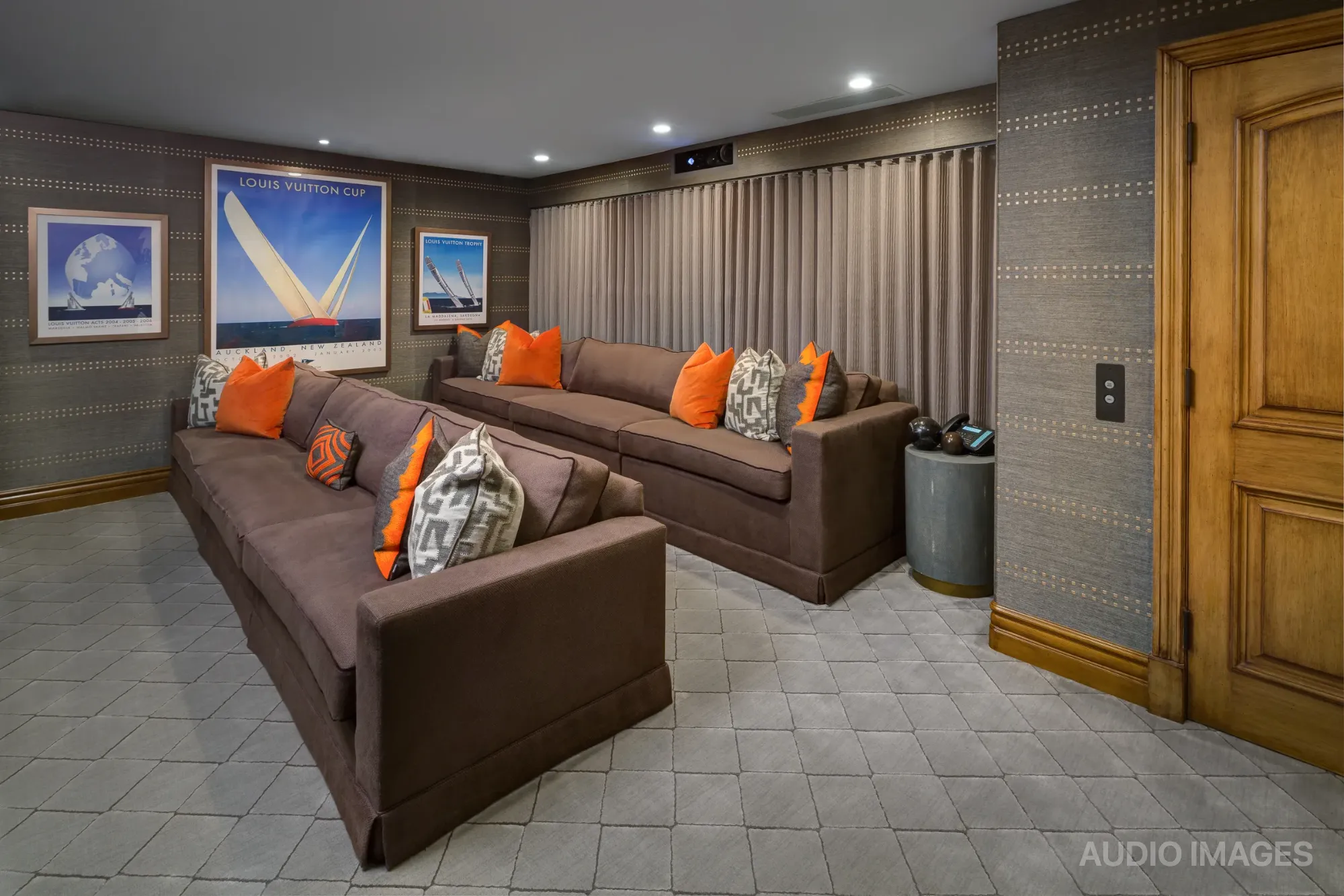 The downstairs media room with two long sofas facing the projection screen.