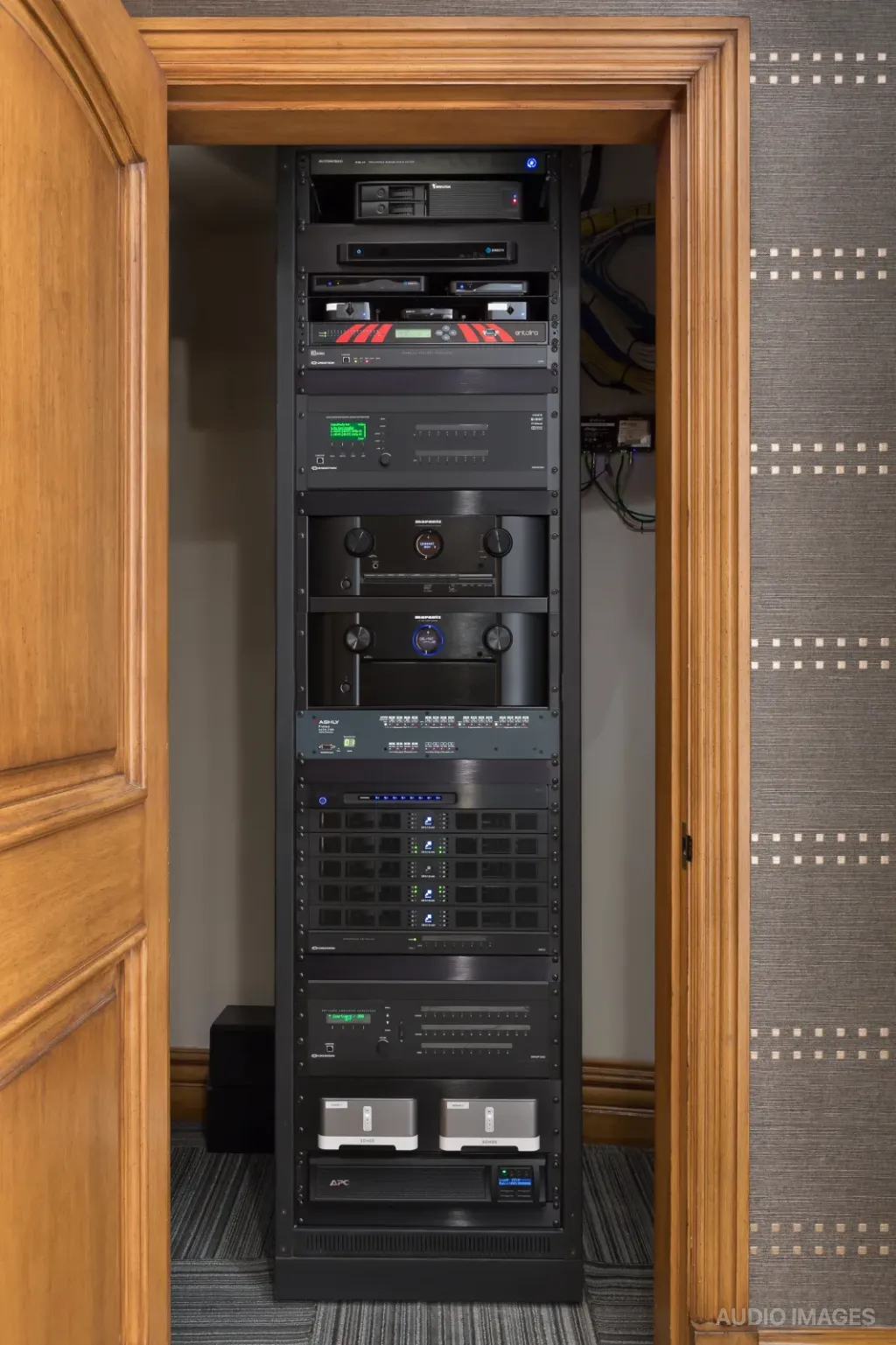 The equipment rack for the house, stacked with audio-visual gear inside its closet.