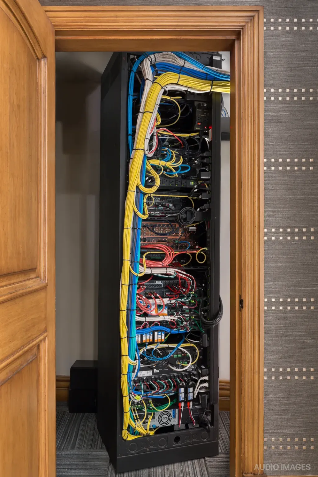 The back of the equipment rack, with color-coded cabling bundled and labeled.