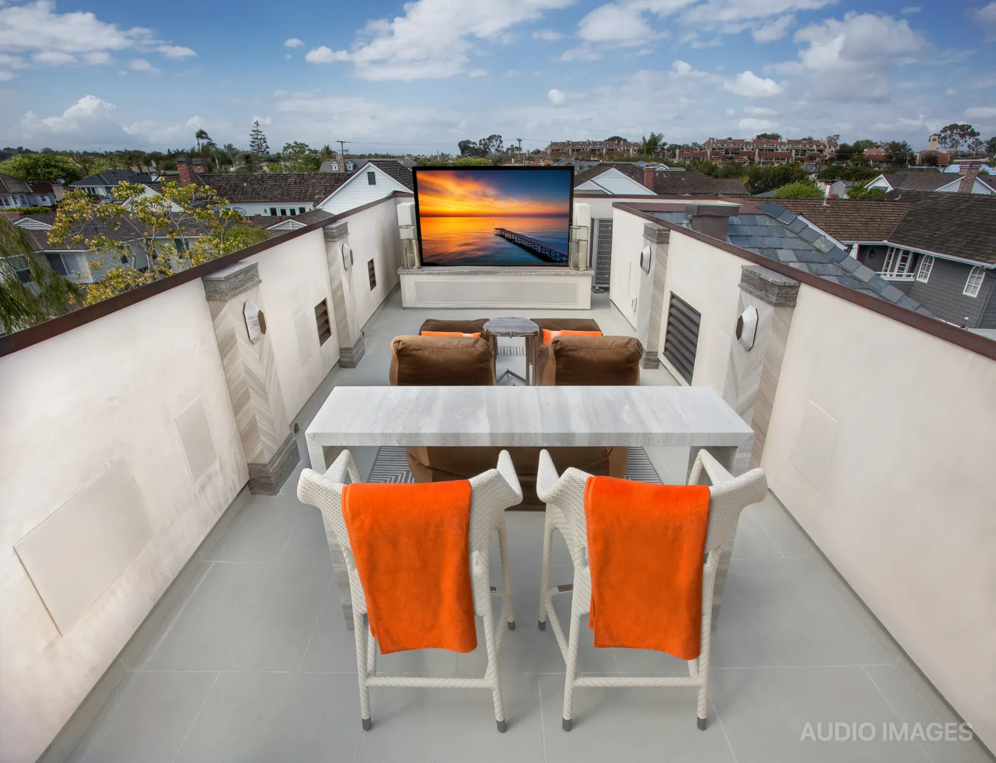 Rooftop deck lounge with low seating and ottomans looking out over Newport Beach bay and its boats.