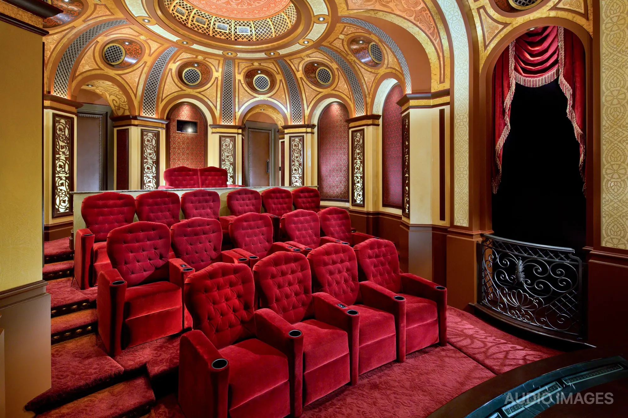 Tiered rows of red velvet recliners under the ornate domed ceiling.
