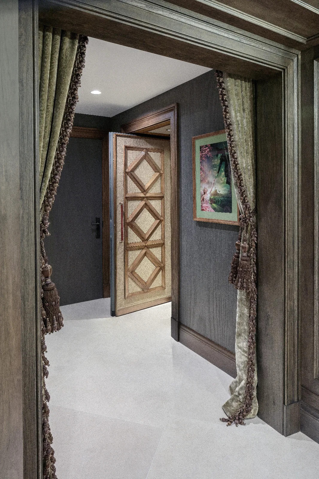 A luxurious hallway featuring dark textured walls, decorative velvet curtains, and an open wooden door with diamond-patterned panels.