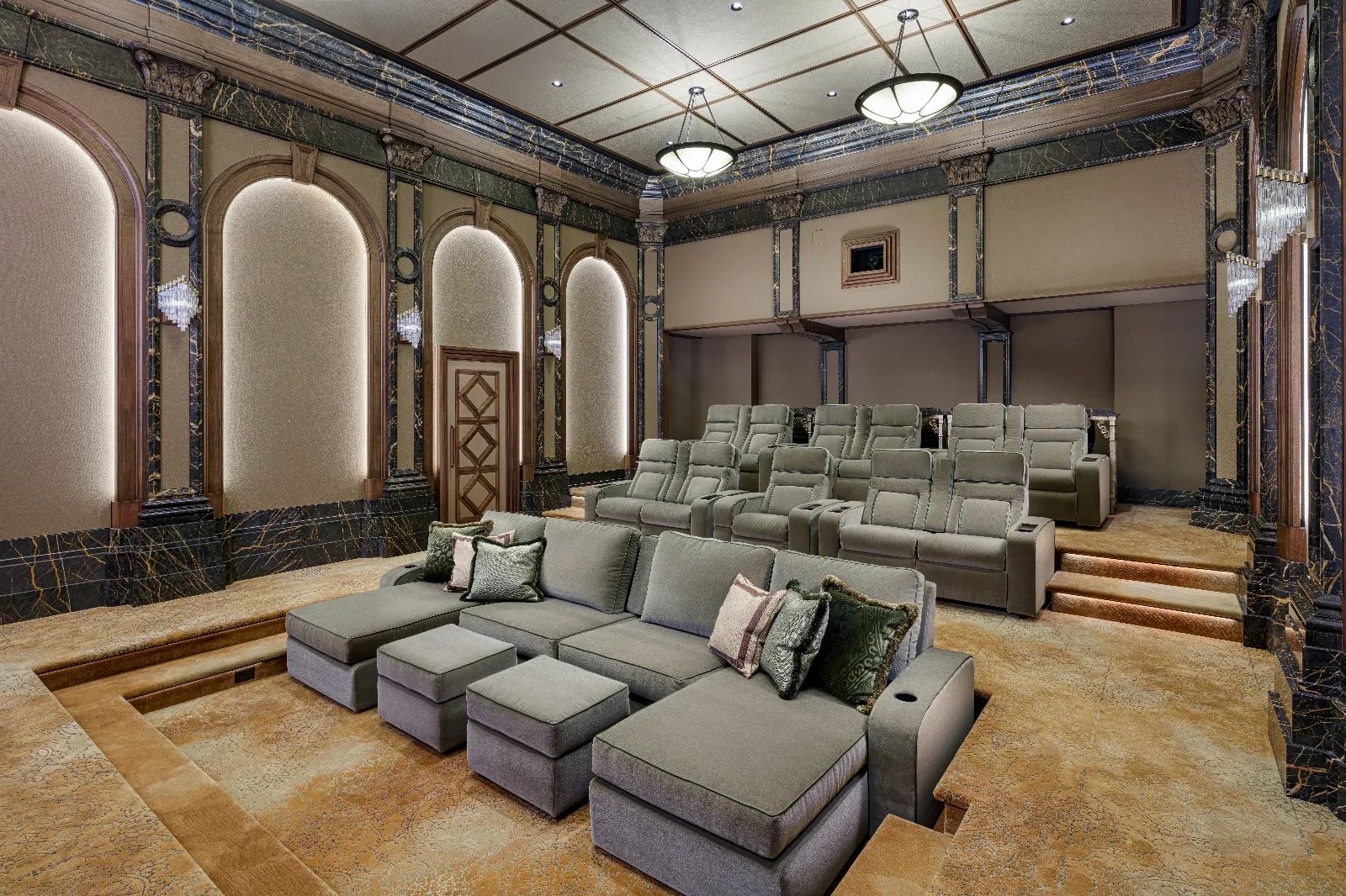 A luxurious home theater with a large gray sectional sofa in front of multiple rows of gray reclining cinema seats.